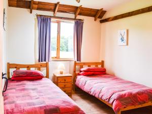 dwa łóżka w pokoju z oknem w obiekcie The Long Barn w mieście Little Baddow