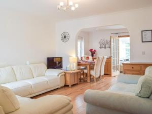 sala de estar con sofá blanco y mesa en Trondra House, en Ferryside