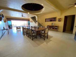 uma grande sala de jantar com mesa e cadeiras em Siete Piedras Beachfront Village em Troncones