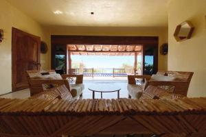 uma sala de estar com cadeiras, uma mesa e um pátio em Siete Piedras Beachfront Village em Troncones