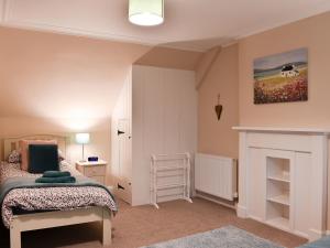 1 dormitorio con 1 cama y chimenea en Ingleside, en Whiting Bay