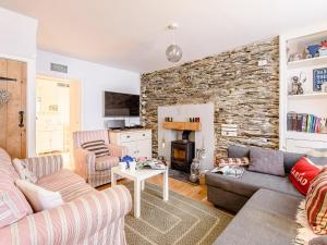 a living room with two couches and a stone wall at Sunny Shores - Uk32245 in Aberdyfi