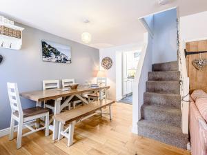a dining room and kitchen with a table and a staircase at Sunny Shores - Uk32245 in Aberdyfi