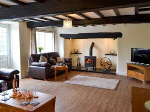 a living room with a couch and a fireplace at Tyddyn Eli in Llangwm