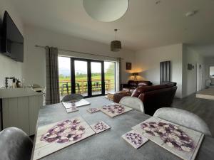 a living room with a table with chairs and a living room at Willow Lodge in Muir of Ord