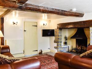 a living room with a couch and a fireplace at Plum Tree Cottage in Trent