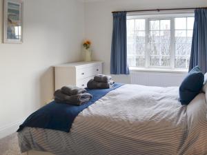 a bedroom with a large bed with towels on it at Bramble Cottage in Craster