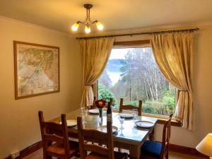a dining room with a table and a large window at Hazelgrove in Inverfarigaig