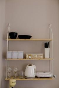 un estante con una tostadora y vasos. en Rooms in Yard en Kórinthos