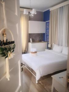 ein Schlafzimmer mit einem großen weißen Bett in einem Zimmer in der Unterkunft Rooms in Yard in Kórinthos
