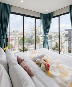 a bedroom with a large white bed and a large window at Crescendo Urban Stay - STAY 24h in Hanoi