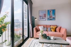 a living room with a pink couch and a balcony at Crescendo Urban Stay - STAY 24h in Hanoi