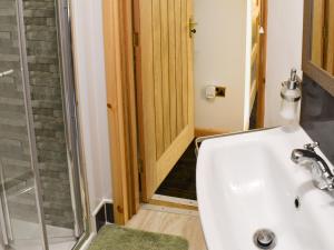 a bathroom with a shower and a white sink at The Archway in Newnham