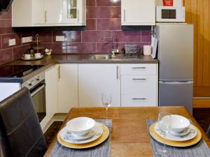 a kitchen with a table with plates and glasses on it at The Archway in Newnham