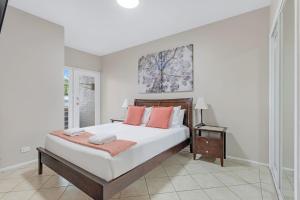 um quarto com uma cama grande e almofadas laranja em Jervis Bay Vista em Huskisson