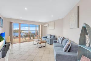 a living room with a couch and a table at Jervis Bay Vista in Huskisson