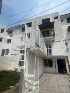 ein weißes Apartmenthaus mit einer weißen Treppe in der Unterkunft Departamento Todo Cerca Playa Azul in Manzanillo