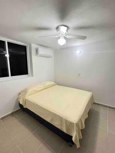 een slaapkamer met een bed en een plafondventilator bij Departamento Todo Cerca Playa Azul in Manzanillo
