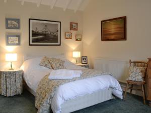 a bedroom with a bed and two tables and two lamps at Inverchroskie Cottage in Enochdhu