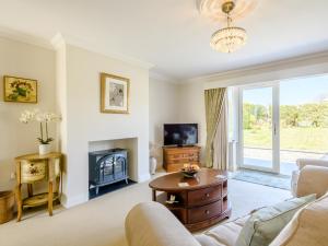 a living room with a couch and a fireplace at Holly Lodge in Hemsby
