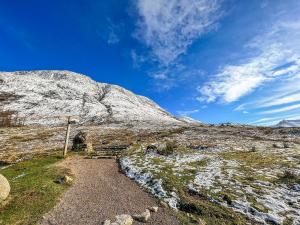 a snow covered hill with a path in front of a mountain at Fernbrae in Fort William