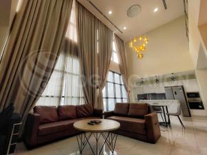 a living room with a couch and a table at Lovely 3-bedrooms with Karaoke Genting Penthouse in Genting Highlands
