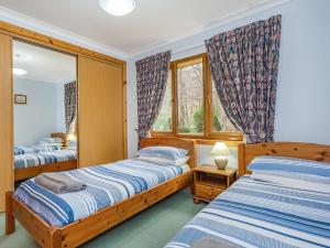 a bedroom with two beds and a mirror at Bidean Lodge in Glencoe