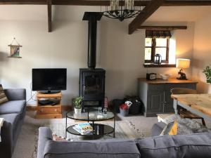 a living room with a couch and a stove at The Pound House in Paignton