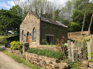 a small brick building with a stone wall at The Old Chapel in Ashover