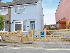 a wooden fence in front of a house at Sapphire Cottage in Pakefield