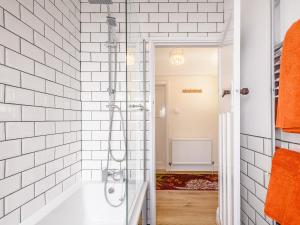 a bathroom with a shower with white tiled walls at Grayson Avenue in Pakefield