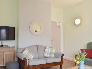 een woonkamer met een bank en een flatscreen-tv bij Sandrock House in Sheringham