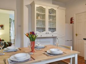 a dining room with a table with plates and glasses at Sandrock House in Sheringham