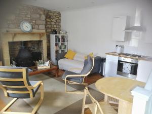 un soggiorno con tavolo, sedie e divano di Oake Cottage a Warkworth