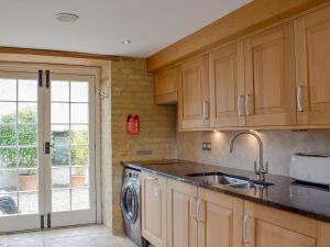 a kitchen with a sink and a washing machine at Brixton Barn in Mottistone