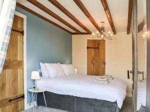 a bedroom with a large bed with white sheets at The Old Stables in Tickton