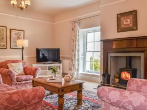 a living room with two chairs and a fireplace at Jenkin Lodge in Braithwaite