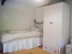 LlangrannogにあるDol Llan - Hw7569のベッドルーム1室(ベッド1台、白いキャビネット付)
