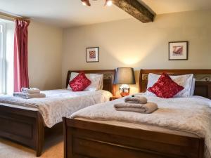 two beds in a bedroom with red pillows at Jenkin Lodge in Braithwaite