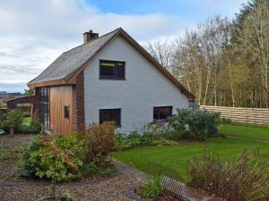 ein kleines weißes Haus mit einem Zaun im Hof in der Unterkunft Glen Rosa in Dalrymple