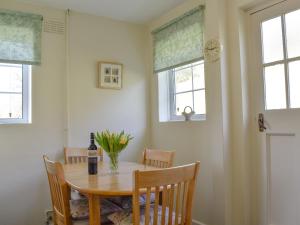 a dining room table with a bottle of wine and flowers on it at Valley View-e1866 in Powerstock