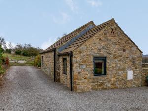 a stone building on a gravel road at Preston Mill Barn in Wensley