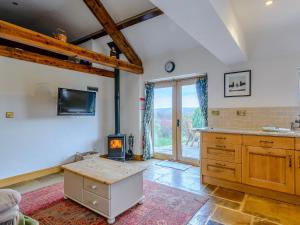 a kitchen with a wood stove in a room at Preston Mill Barn in Wensley