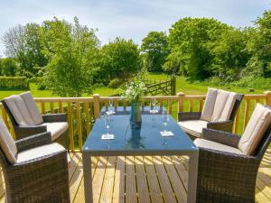 een terras met een tafel en stoelen bij Rockville Lodge - Uk2503 in Bempton
