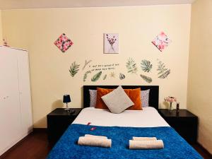 um quarto com uma cama com um cobertor azul em Estoril Seaside Guest House em Estoril