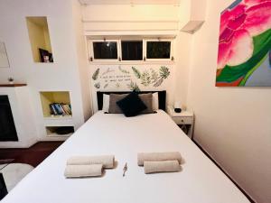 a bedroom with a large white bed with two pillows at Estoril Seaside Guest House in Estoril