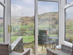 a view from the front door of a cottage with a table and chairs at Hovera in Glenridding