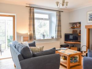 sala de estar con sofá y mesa en Hovera, en Glenridding