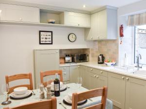 a kitchen with a table and chairs and a clock on the wall at Hovera in Glenridding