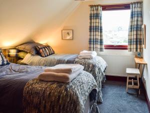 a bedroom with two beds and a window at Braeside House in Tobermory